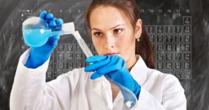 The picture of a very young female college student do chemistry experiments.