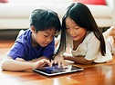 The picture of a little boy and little girl engaging their fun learning tablet.