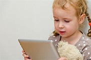 The picture of a very little girl, plating on her tablet!!